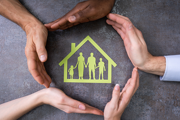 Person Hands Protecting Family Home